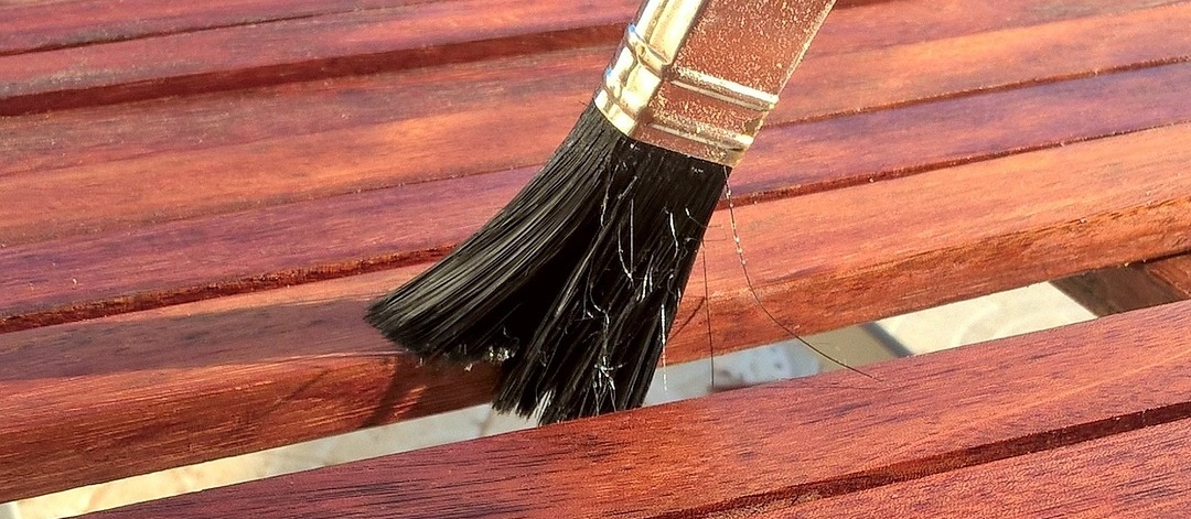 Applying deck stain with a brush